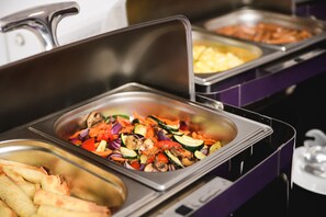 A buffet with various food options including vegetables and meats.