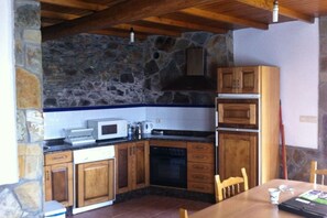 Een koelkast, een microgolfoven, een oven, kookgerei, borden en bestek