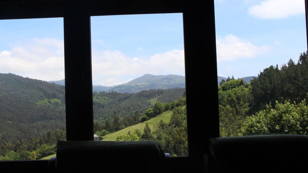 A room with a large window offering a view of a green valley and hills. - Pitos House, Fijuecas (Fijuecas)