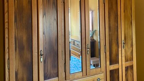 A wooden wardrobe with mirrored doors and multiple drawers. - Pitos House, Fijuecas (Fijuecas)