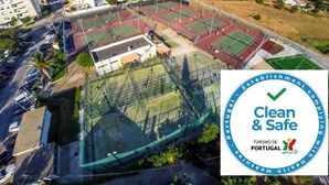 Luchtbeeld van een sportcomplex met verschillende tennisbanen, omringd door woongebouwen.
