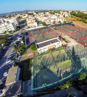 An aerial view of a sports complex with multiple tennis courts, surrounded by residential buildings. - Private Studio - A/C (Faro)