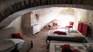 A cozy attic bedroom with two beds, a small table, and a chair.