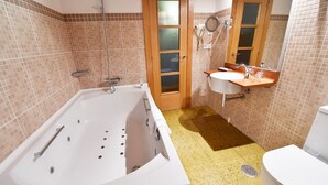 A bathroom with a bathtub, a sink, and a toilet. - Posada Término (Entrambasaguas)