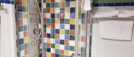 Ducha con cabina de vidrio, paredes de azulejo y techo de madera.
