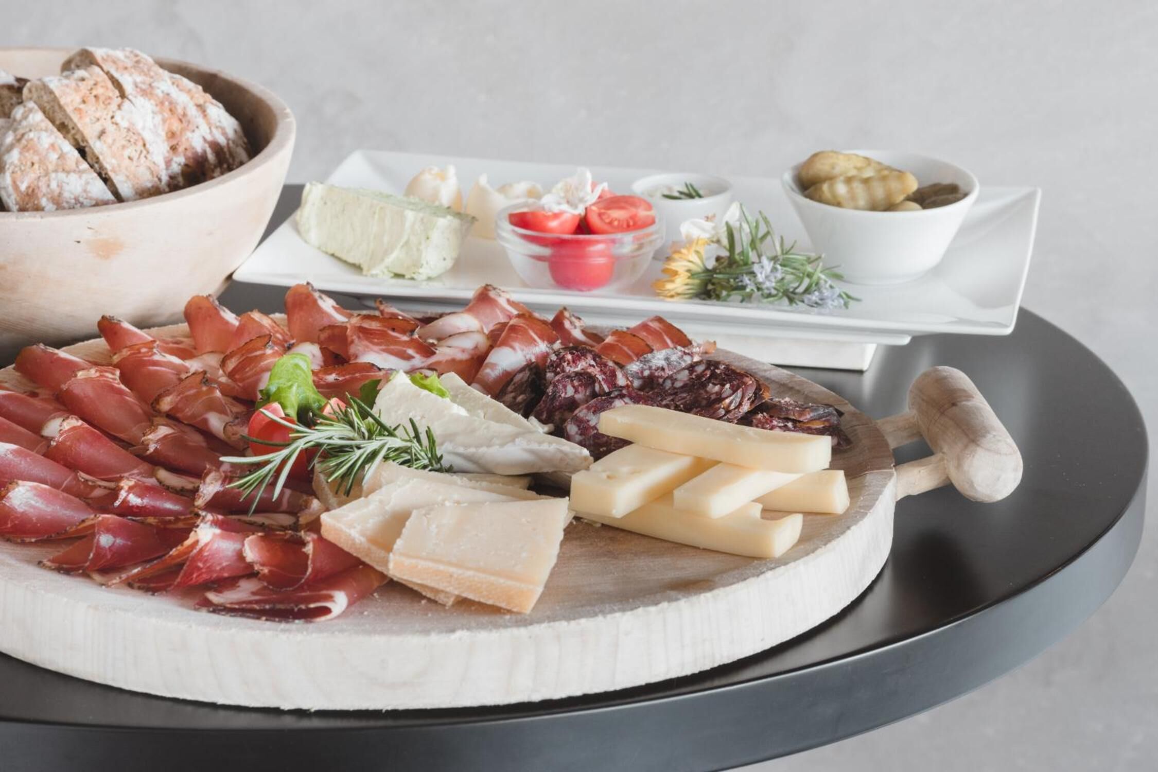 A charcuterie board with various meats, cheeses, and accompaniments.