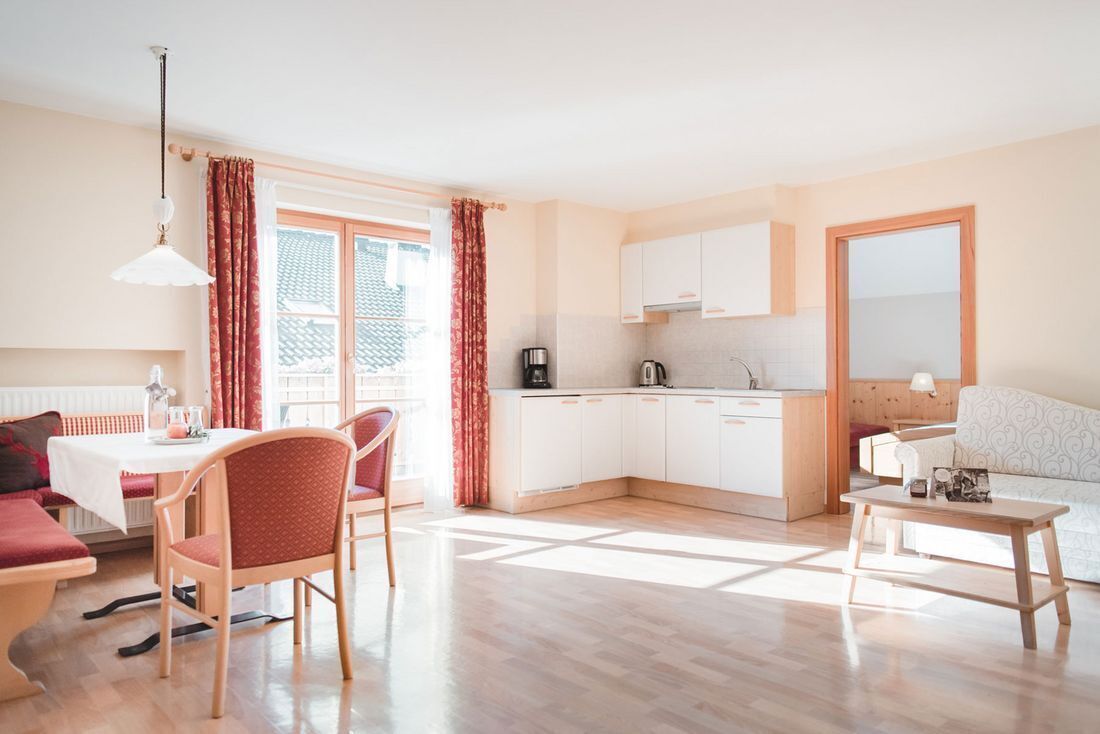 A bright, open-plan living space with a dining area, kitchen, and seating area.