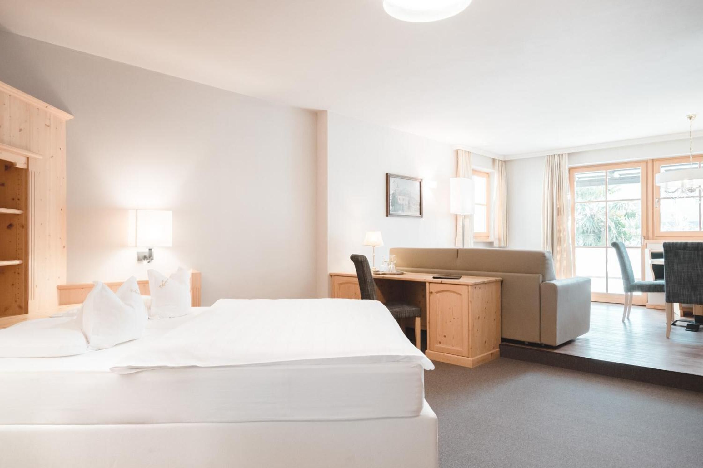 Habitación de hotel con cama, escritorio y zona de estar.