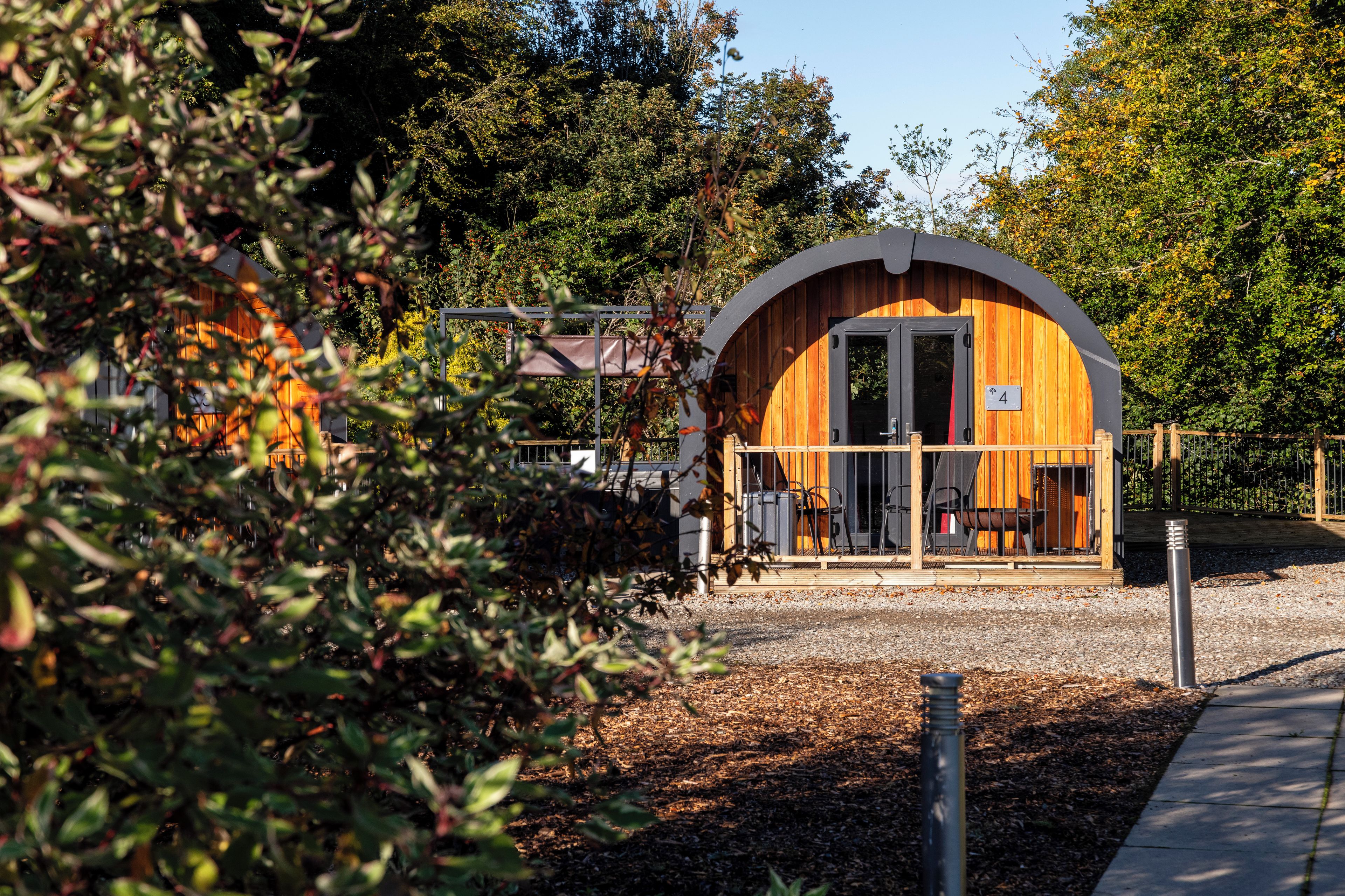 A small, wooden structure with a curved roof, a door, and a number sign indicating its unit.