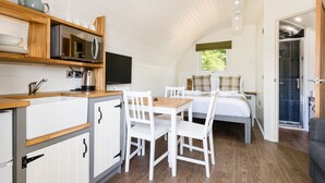A compact room with a kitchenette, a dining area, and a bed. - Weedingshall Lodges (Falkirk)