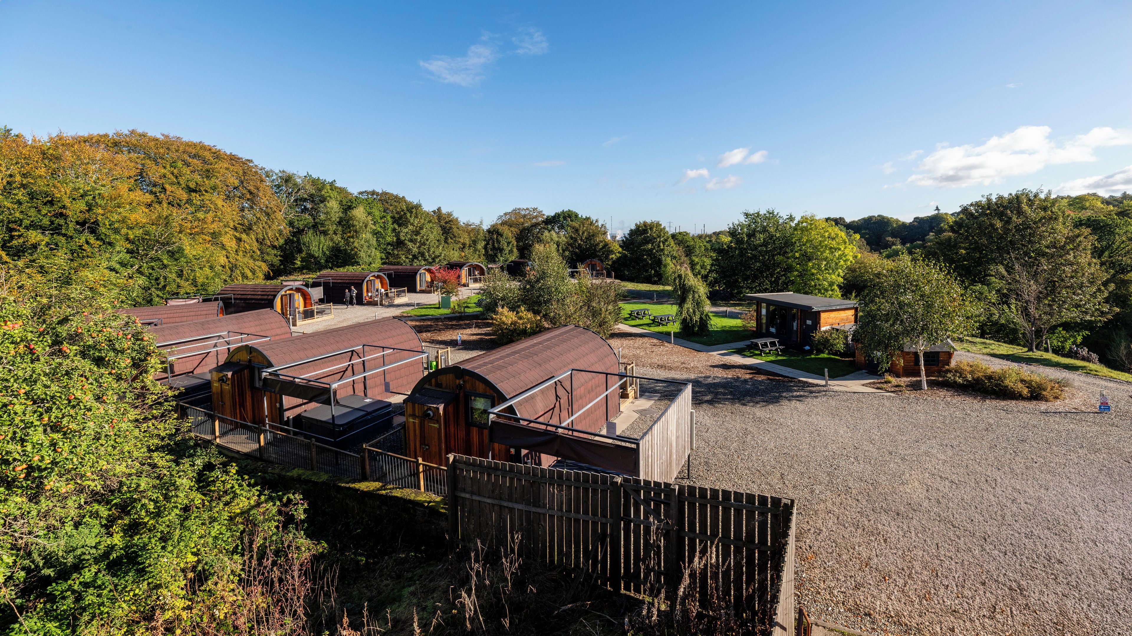 A rural property with multiple barns, a picnic area, and a gravel driveway.