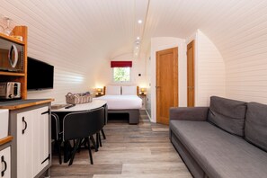 Une pièce compacte comprenant un coin cuisine, un espace repas, un lit et un canapé.
