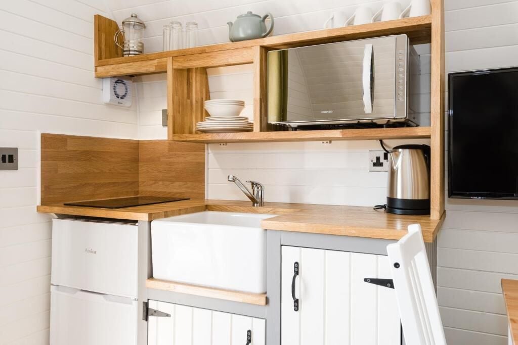 A compact kitchen with a built-in oven, a sink, and a microwave.