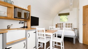 A compact room with a kitchenette, a dining area, and a bed. - Weedingshall Lodges (Falkirk)