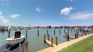 Un puerto deportivo con barcos amarrados, un muelle de madera y un cielo despejado.