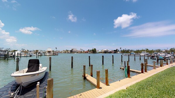 A marina with boats docked, a wooden dock, and a clear sky. - Driftwood Landing 10- Isles of Capri Vacation Resort (Naples)
