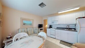 Cozy living space with a kitchenette, dining area, sofa, and TV.