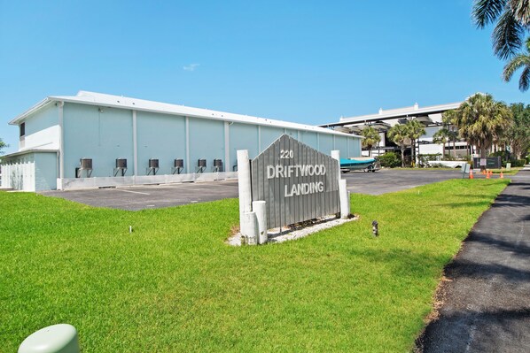 A building with a sign reading 'DRIFTWOOD LANDING' and a parking lot.