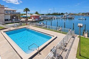 A swimming pool with a view of a marina and boats.