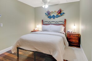 A bedroom with a bed, nightstands, a dresser, and a decorative wall piece. - Driftwood Landing 13- Isles of Capri Vacation Resort. (Naples)