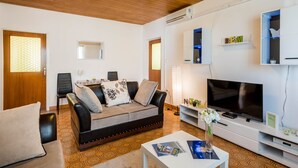 Un salon avec un canapé, un téléviseur et une table basse.