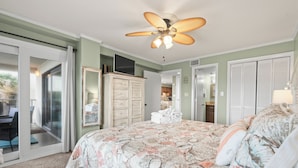 A bedroom with a bed, a ceiling fan, a wardrobe, and a sliding glass door leading to a patio. - Tidemaster. 3 bedroom oceanfront condo 1st floor with elevator. Pool. (North Myrtle Beach)