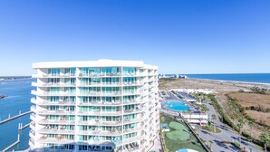 Un hôtel à plusieurs étages doté de balcons, d’une piscine et offrant une vue sur l’océan.