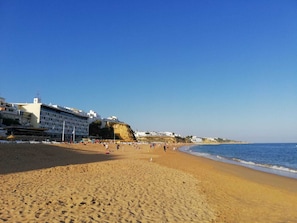 A beach with a hotel in the background. - "Logis des fées" Apartment, 2 bedrooms, Marina d'Albufeira, Algarve, Portugal. (Albufeira)