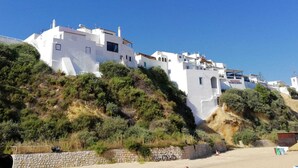 A white building with multiple balconies and a stone wall in the foreground. - Apartment "Logis des fées", 2 bedrooms, Marina d'Albufeira, Algarve, Portugal. (Albufeira)