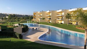 A hotel with a swimming pool, multiple balconies, and a well-maintained lawn. - Apartment "Logis des fées", 2 bedrooms, Marina d'Albufeira, Algarve, Portugal. (Albufeira)