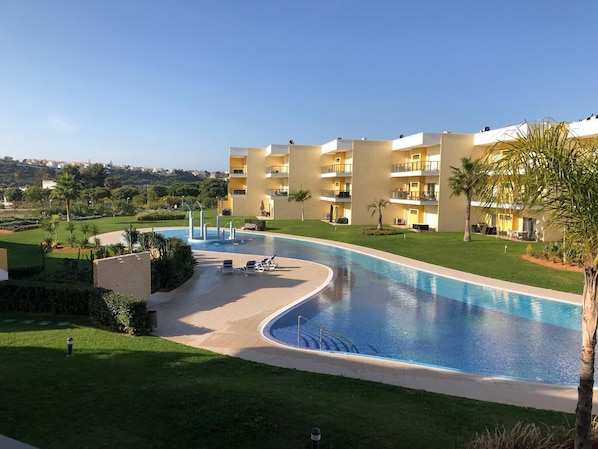 A hotel with a swimming pool, multiple balconies, and a well-maintained lawn. - "Logis des fées" Apartment, 2 bedrooms, Marina d'Albufeira, Algarve, Portugal. (Albufeira)