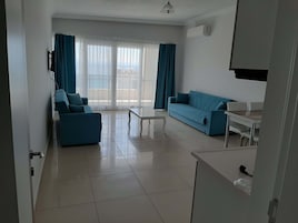Apartamento familiar, 1 habitación, vistas al mar | Zona de estar | Televisión LCD de 82 pulgadas con canales por satélite, una televisión