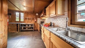 Una cocina de madera con encimeras de granito, un fregadero y alacenas.