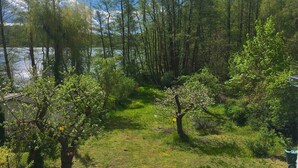 Un paysage naturel comprenant un lac, une forêt dense et une zone herbeuse.