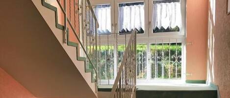 A staircase with a metal railing leading to a landing.