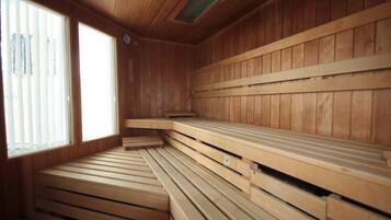 A sauna with wooden benches and a sloped floor design.