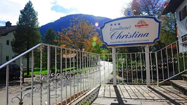 A sign for Landhotel Christina with a mountain backdrop. - Hotel Kienberger Hof (Pfronten)