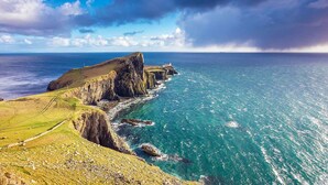 A coastal landscape with a rugged cliff, a narrow path, and a view of the sea. - Piper's Hut - Central apartment  (Portree)