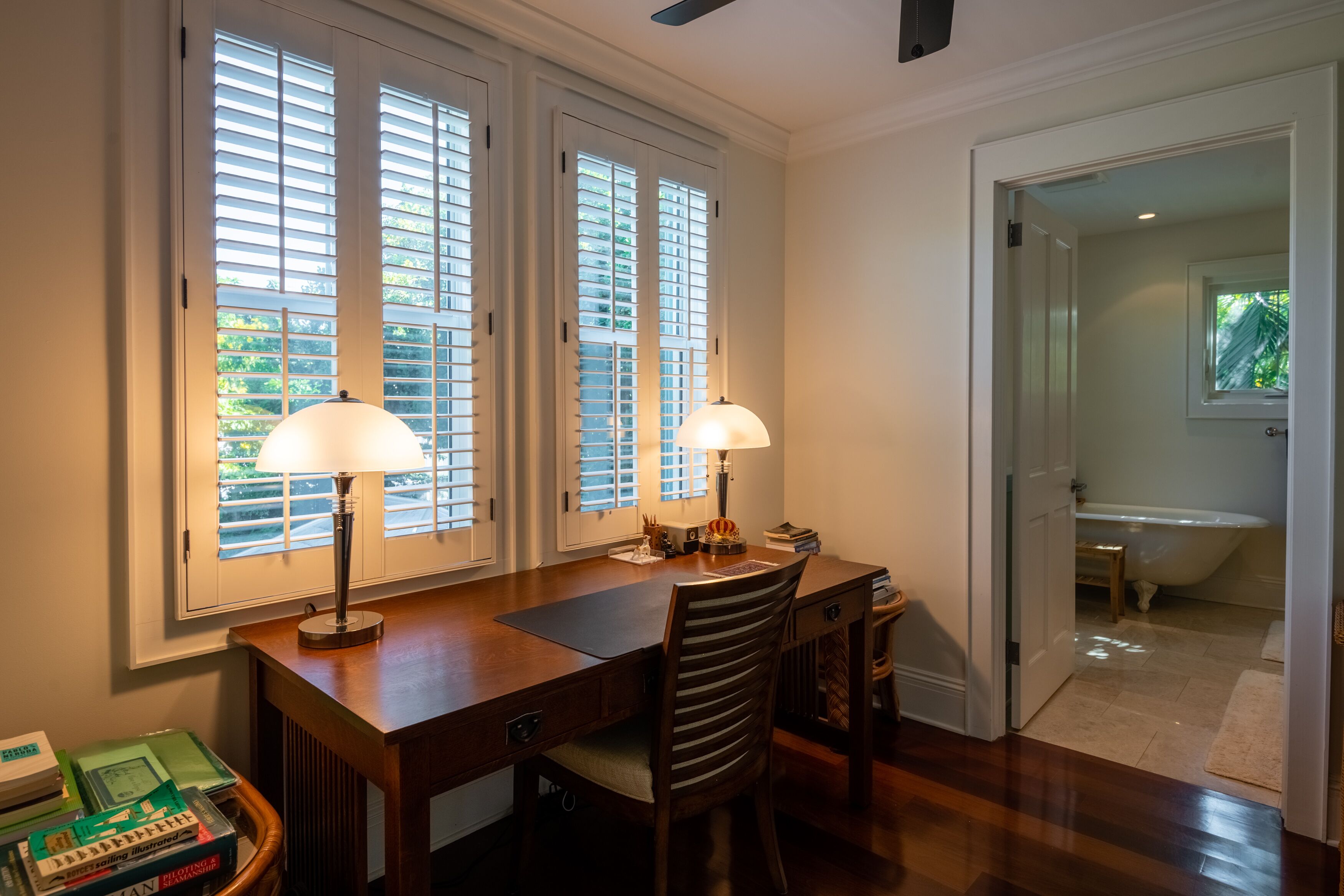 Una habitación con un escritorio, dos lámparas y una silla.