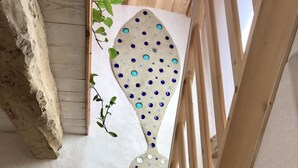 A staircase with a unique wall design featuring circular and square patterns. - Renovated wine cellar in the heart of nature (Villetritouls)
