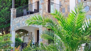 A stone building with a balcony, surrounded by lush greenery. - The Mara Suite (Bodrum)