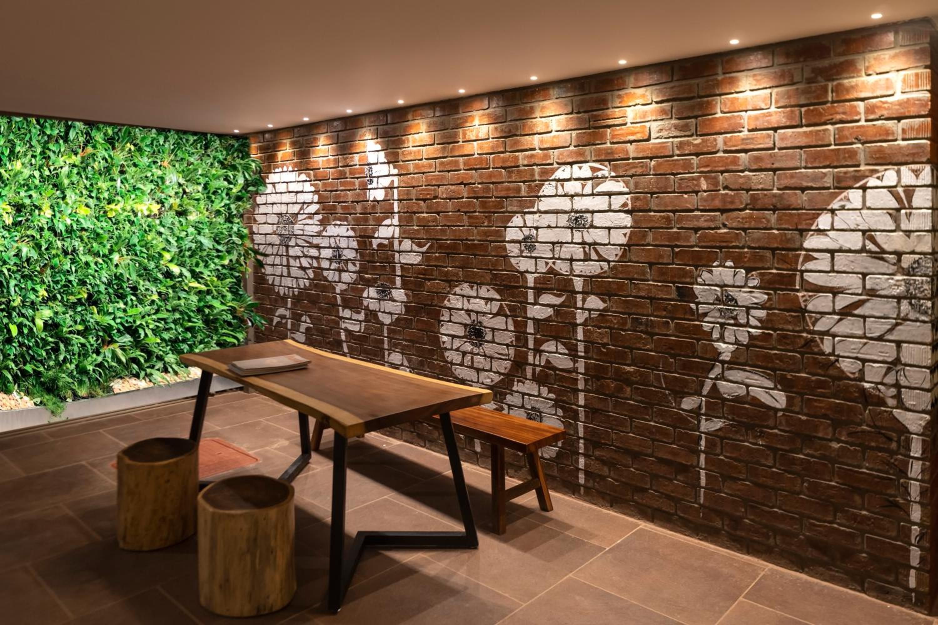A modern interior with a brick wall and a green plant wall.