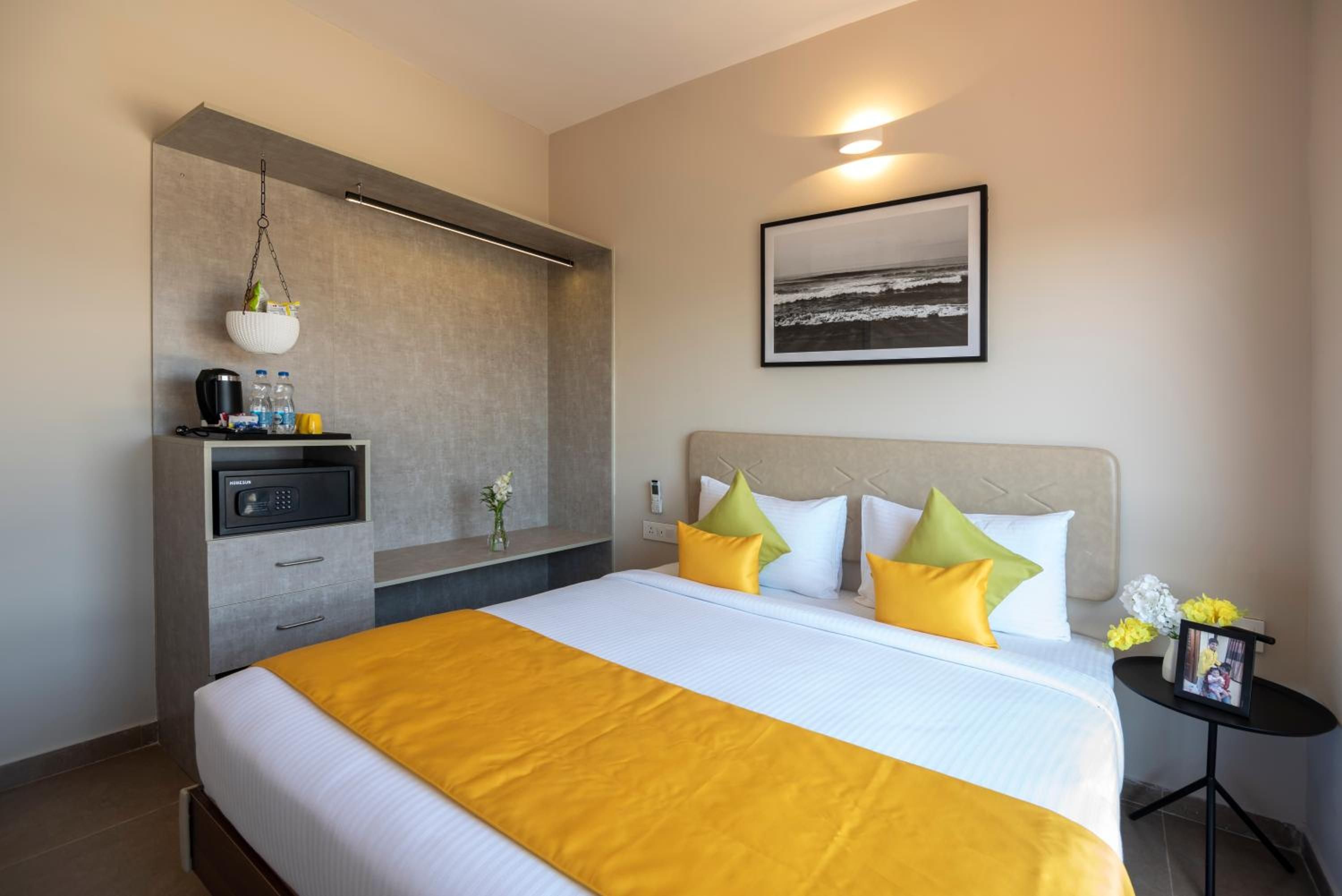 A hotel room with a bed, bedside table, and a wall-mounted TV.