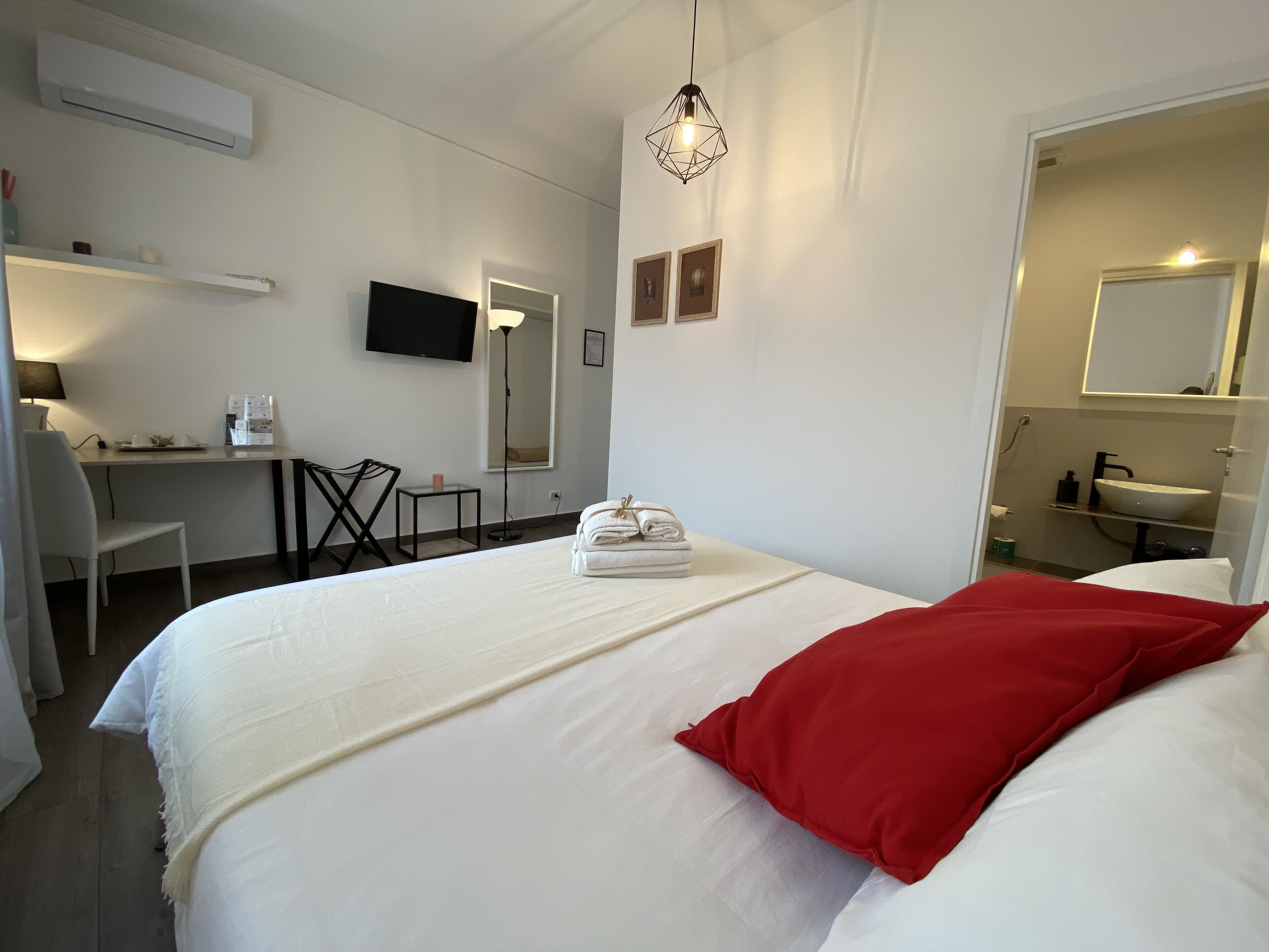 Une chambre d’hôtel comprenant un lit, un bureau, une chaise, une télévision et une salle de bain.
