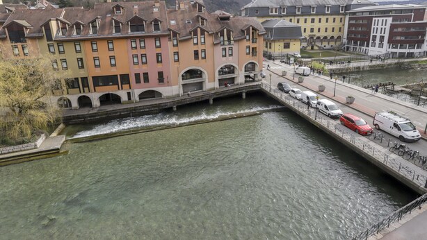 A canal-side building with multiple floors, a pedestrian bridge, and a waterway. - Superbe 120m2 - 2chambres + 2sdb, 3 Grds Balcons (Annecy)