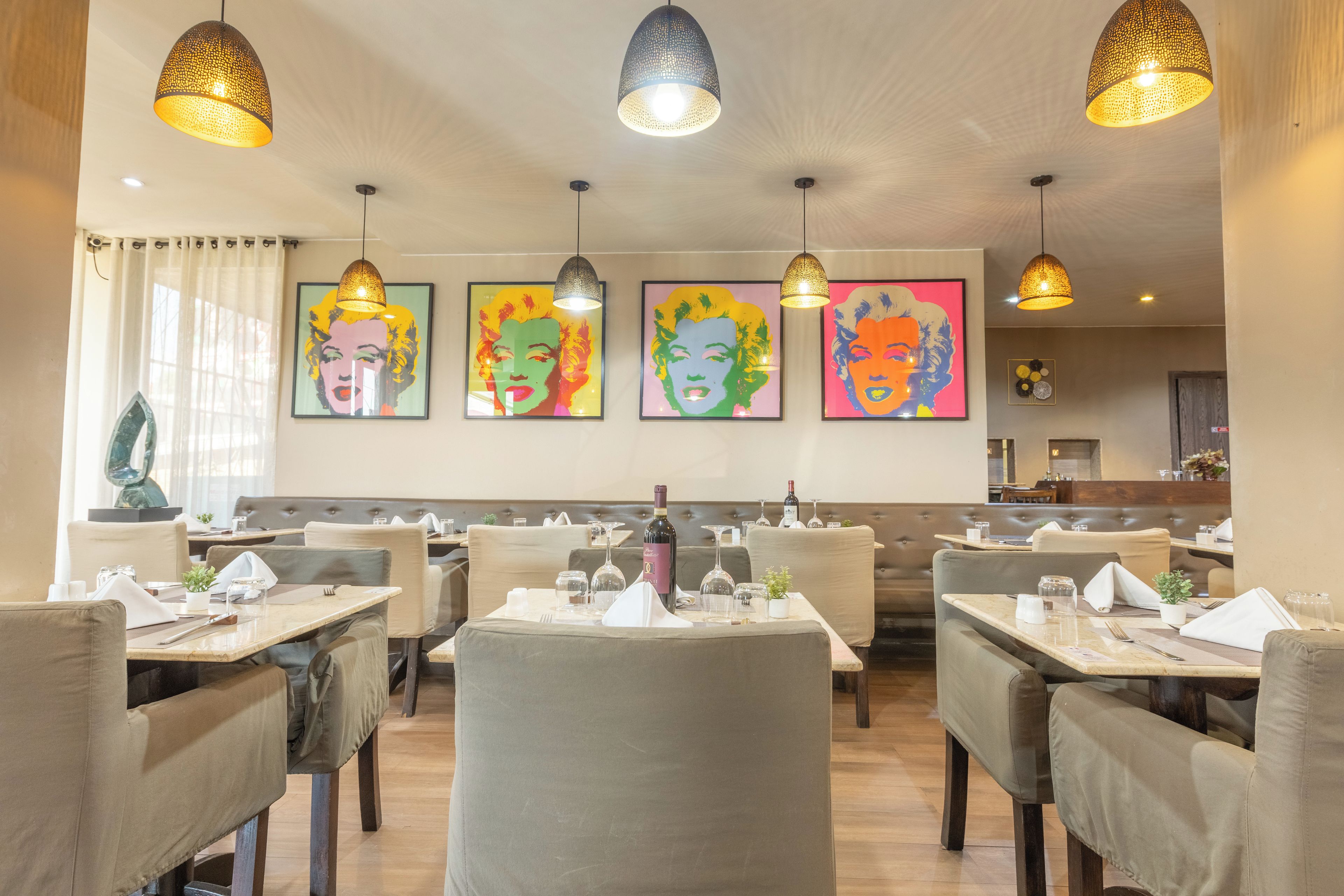 Ein Restaurantinneres mit Sitzbänken, Tischen und Bildern an den Wänden.