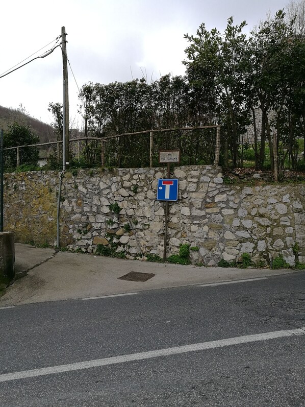 A stone wall with a blue sign indicating a parking area. - De Angelis House | Amalfi Coast, Ocean View Terrace (Sant' Agnello ( Fraz. Colli di Fontanelle))
