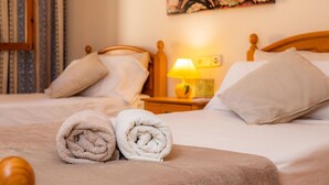 Een hotelkamer met twee bedden, een lamp en een schilderij van de Eiffeltoren.