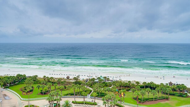 A beach resort with a well-maintained lawn, palm trees, and a view of the ocean. - MAKE OFFER JULY 5-10 Stunning Gulf Views, 3 Bed 3 Bath Silver Shells Resort (Destin)