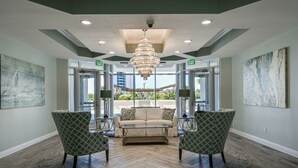 A lobby with a chandelier, a sofa, two armchairs, and a coffee table. - MAKE OFFER JULY 5-10 Stunning Gulf Views, 3 Bed 3 Bath Silver Shells Resort (Destin)